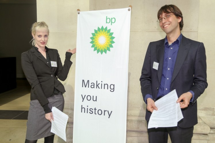 Fake BP staff pose by banner. Photo by Diana More